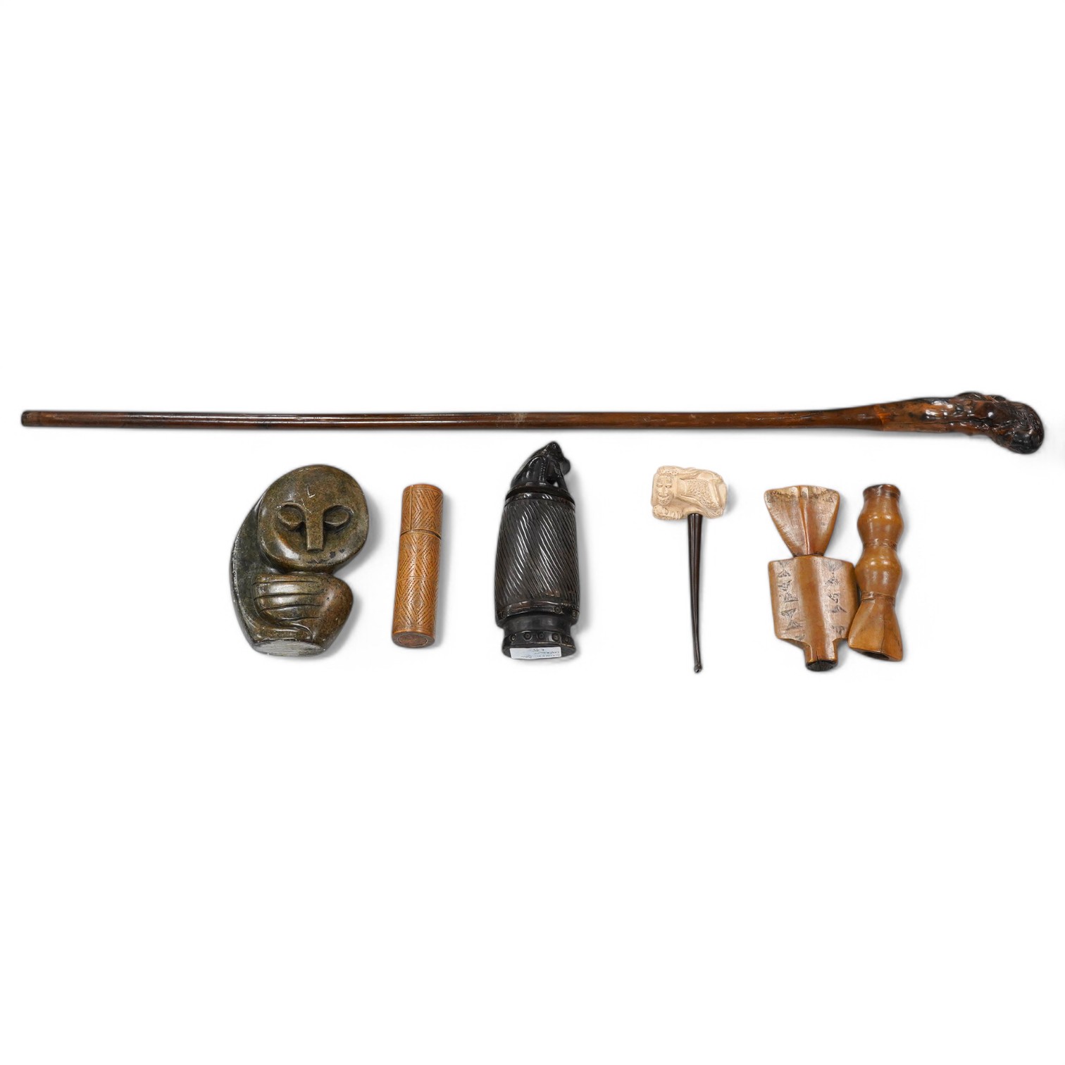 A carved root handled walking stick, a carved Indonesian horn container, an African Honer sculpture, a carved clay pipe etc (6), Walking stick 84cm long. Condition- walking stick and container split, other items fair to